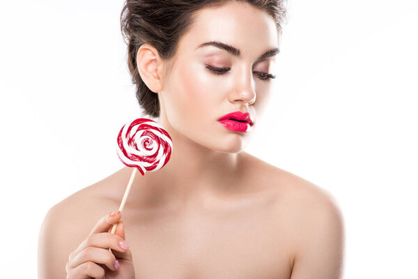 tender woman with closed eyes holding red lollipop, isolated on white