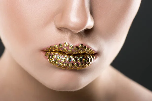 グレーに分離された黄金色の唇を持つ女性の部分的なビュー — ストック写真