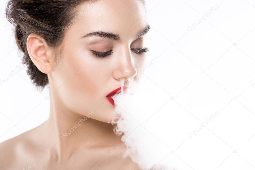 attractive young woman blowing smoke, isolated on white