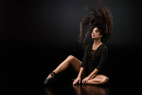 暗い背景にポーズ黒のボディー スーツとバレエ シューズの若い魅力的なバレリーナ — ストック写真