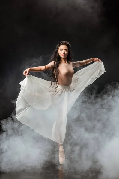 Красивая Молодая Балерина Белой Юбке Танцует Темном Фоне Дымом Вокруг — Бесплатное стоковое фото