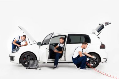 Lastik şişirme, dizüstü bilgisayar kullanarak ve beyaz kaputa seyir yakışıklı otomatik mekanik