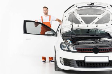 yakışıklı otomatik mekanik ayakta açık hood ve beyaz kapı ile araba yakınındaki