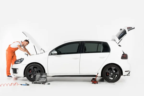 白の壊れた車を修理ハンサムな自動車整備士 — ストック写真