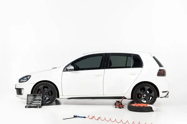Zijaanzicht Van Een Nieuwe Witte Auto Met Tools Wit Vloer — Gratis stockfoto