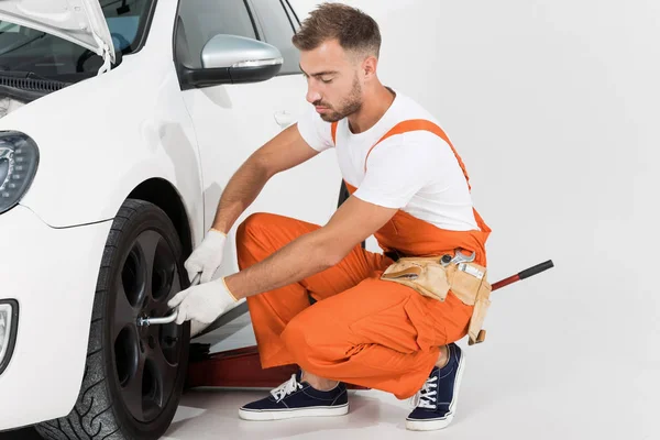 Mecánico Auto Guapo Que Fija Neumático Del Coche Blanco — Foto de Stock