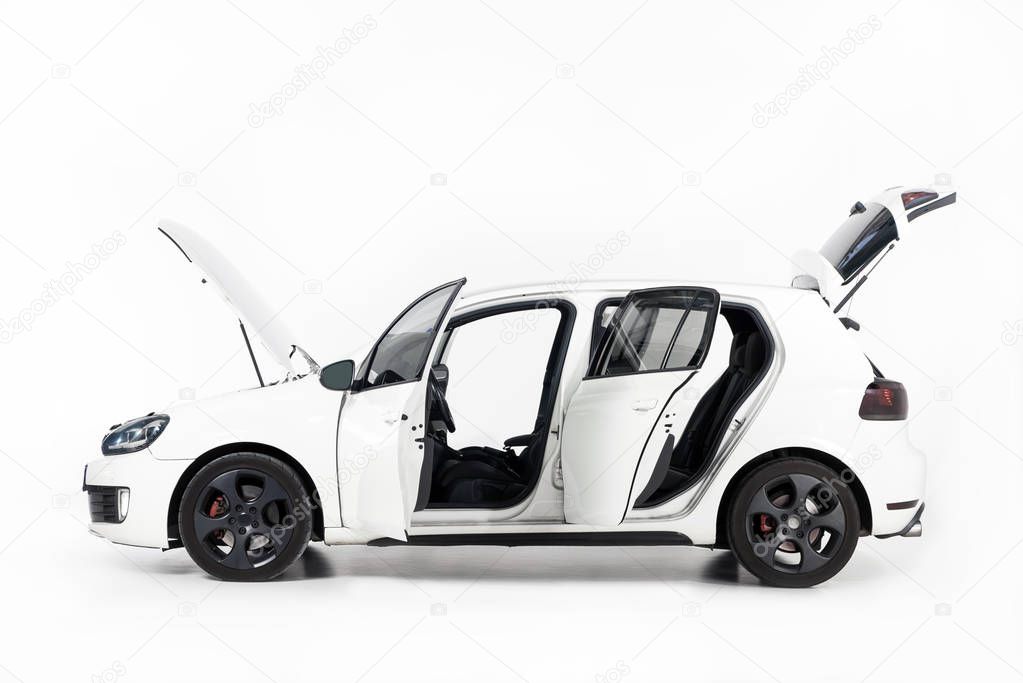 side view of new white car with open doors and open hood on white