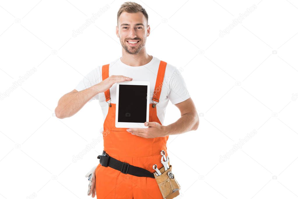 handsome auto mechanic in orange uniform holding tablet with blank screen isolated on white