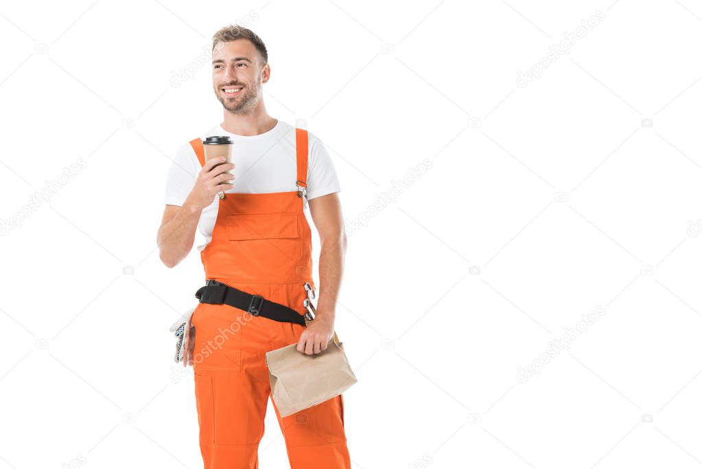 handsome auto mechanic holding coffee to go and paper bag with lunch isolated on white