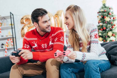 Genç iskambil video oyunu oyun çubukları ile Noel arifesinde çift
