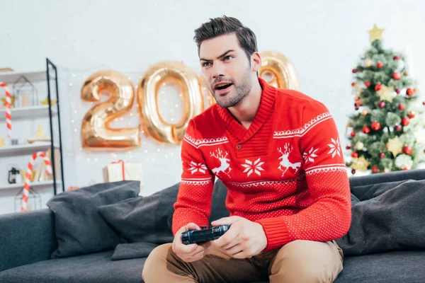 Homem Concentrado Jogando Videogame Com Joystick Durante Ano Novo — Fotografia de Stock