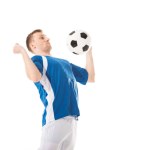 Joven futbolista golpeando pelota con pecho aislado en blanco