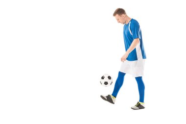 side view of young soccer player kicking ball and looking down isolated on white clipart