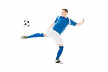 full length view of athletic young soccer player kicking ball isolated on white clipart