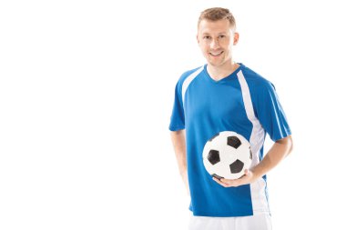 futbol topu tutarak ve üzerinde beyaz izole kamera gülümseyen mutlu genç sporcu