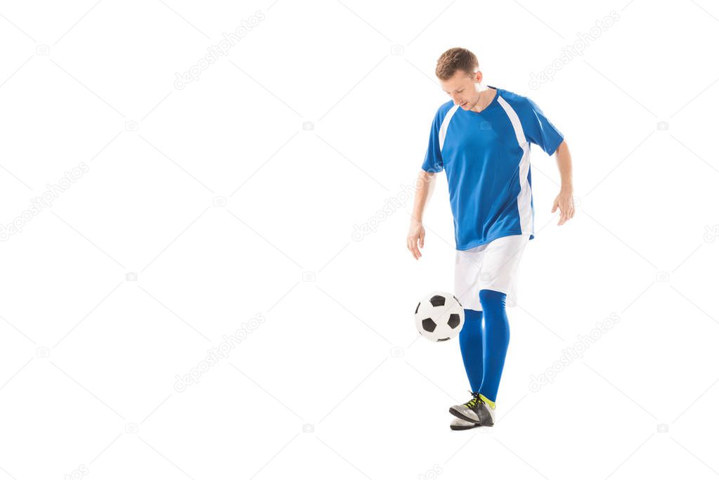 full length view of young sportsman playing with soccer ball isolated on white