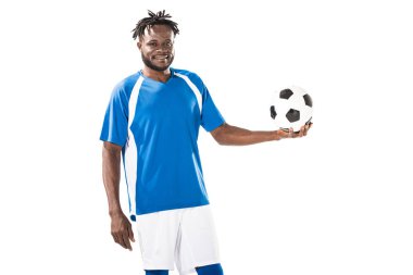 futbol topu tutarak ve üzerinde beyaz izole kamera gülümseyen mutlu Afrika kökenli Amerikalı sporcu 