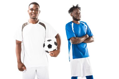 mutlu genç Afro-Amerikan futbol oyuncu holding topu ve gülümseyen sporcu çapraz kolları üzerinde beyaz izole olan ayakta