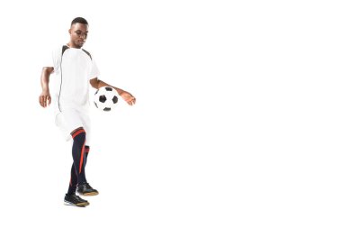 yakışıklı genç Afro-Amerikan sporcu üzerinde beyaz izole futbol topu ile oynarken görünümünü tam uzunlukta
