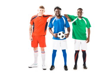 birlikte duran ve üzerinde beyaz izole kamera gülümseyen mutlu çok ırklı futbol oyuncuları görünümünü tam uzunlukta   