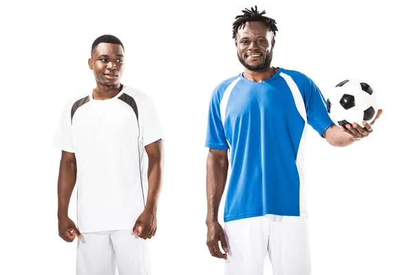 handsome smiling young african american soccer players standing with ball isolated on white
