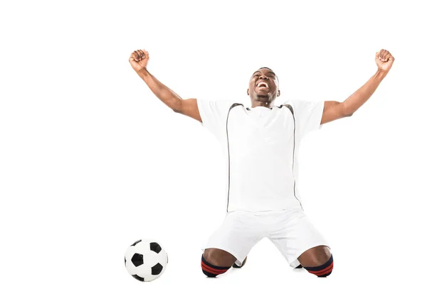 Emocionado Joven Afroamericano Futbolista Arrodillado Cerca Bola Aislado Blanco — Foto de stock gratis