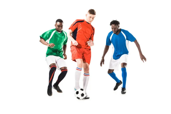 three multiethnic sportsmen playing with soccer ball isolated on white