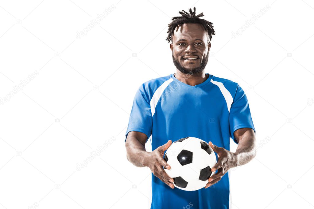 african american soccer player holding ball and smiling at camera isolated on white  