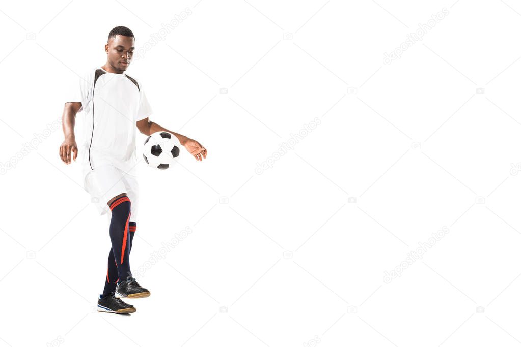 full length view of handsome young african american sportsman playing with soccer ball isolated on white