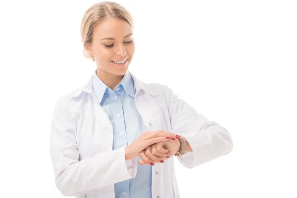 Sonriente Joven Médico Comprobando Tiempo Con Reloj Pulsera Aislado Blanco — Foto de Stock