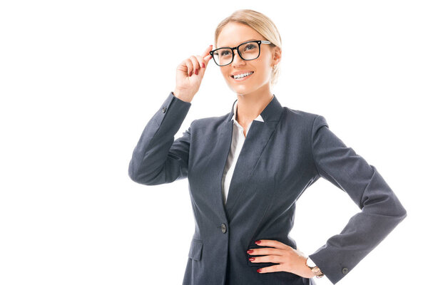 attractive young businesswoman in grey suit and eyeglasses looking away isolated on white