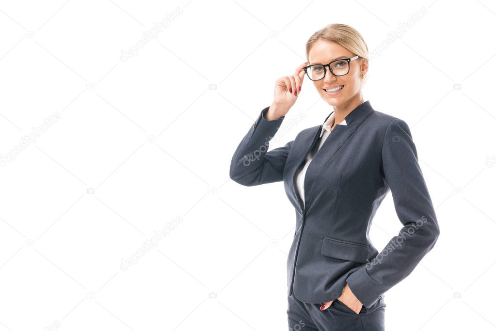 beautiful young businesswoman in suit looking at camera through eyeglasses isolated on white