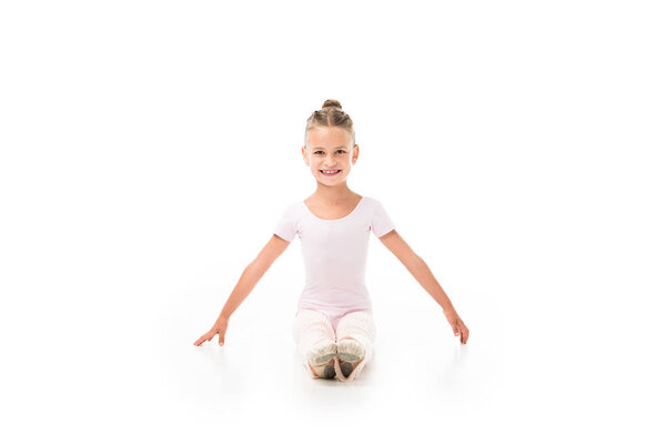 smiling little ballerina practicing isolated on white background 