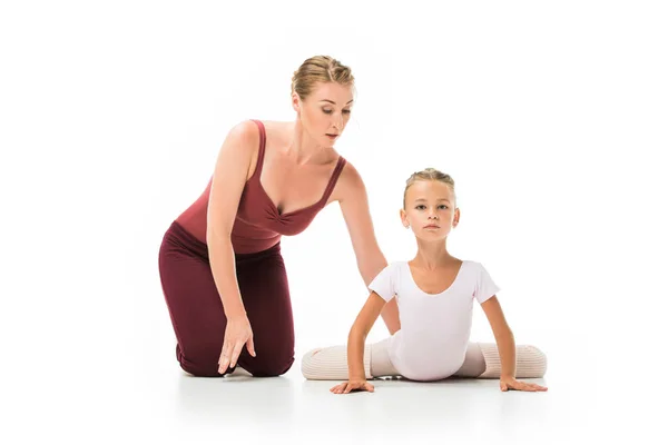 Fokussierte Trainerin Hilft Der Kleinen Ballerina Sich Isoliert Auf Weißem — kostenloses Stockfoto