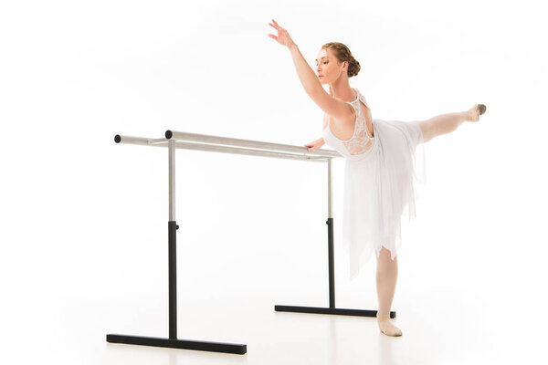 взрослая балерина в балетной балетной пачке и пуантах на белом фоне
 