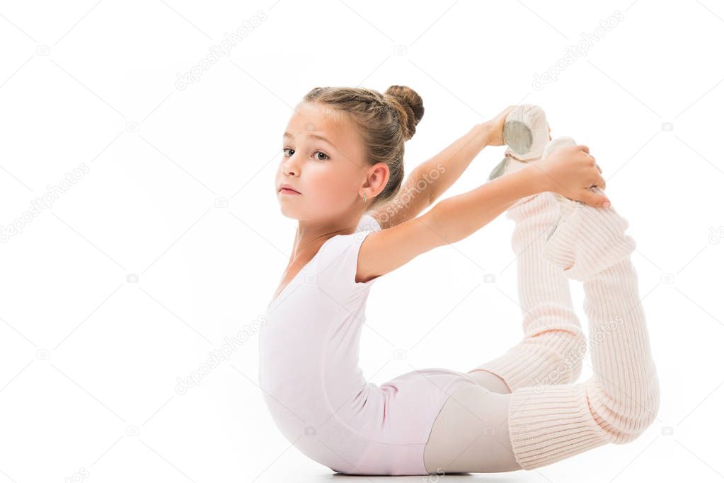 beautiful little child doing gymnastics exercises isolated on white background 