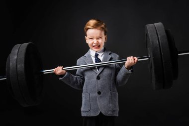 güçlü küçük çocuk takım elbise gri izole halter kaldırma