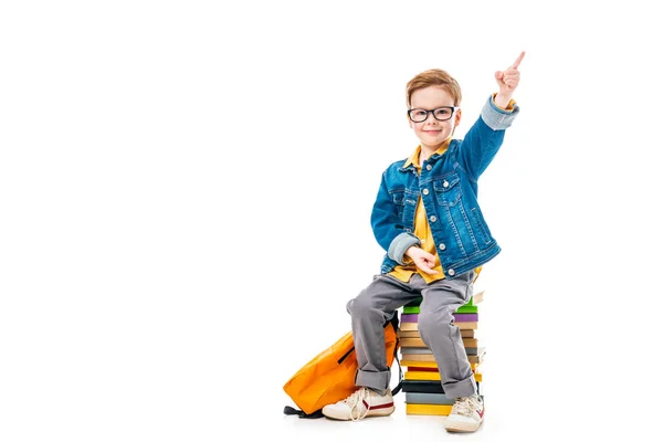 Smiling Schoolboy Pointing While Sitting Pile Books Backpack Isolated White — Stock Photo, Image