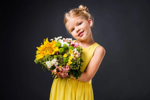 Stylisches Lächelndes Kind Gelbem Kleid Mit Blumenstrauß Isoliert Auf Grau — Stockfoto