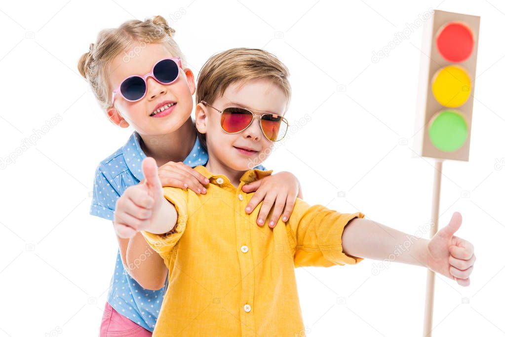 stylish children in sunglasses, boy showing thumbs up, isolated on white with cardboard traffic lights on background