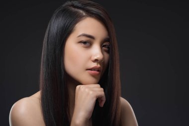 portrait of young asian woman with beautiful and healthy dark hair looking at camera isolated on black clipart