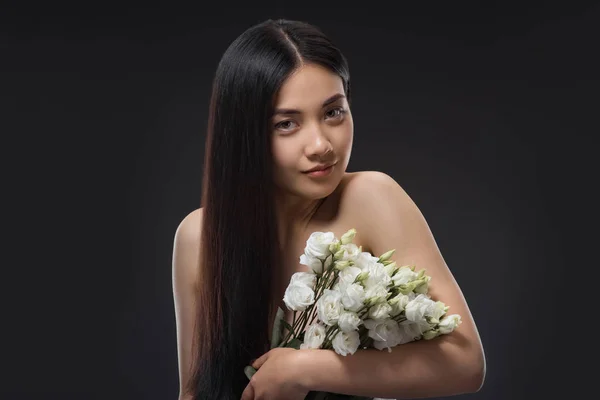 亚洲妇女的肖像与美丽的黑发和白色洋花花束在黑色隔离 — 免费的图库照片