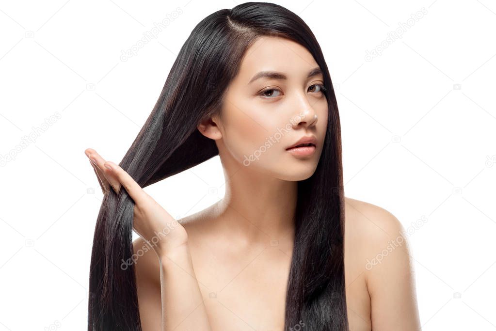 portrait of attractive asian model with strong and healthy hair looking at camera isolated on white