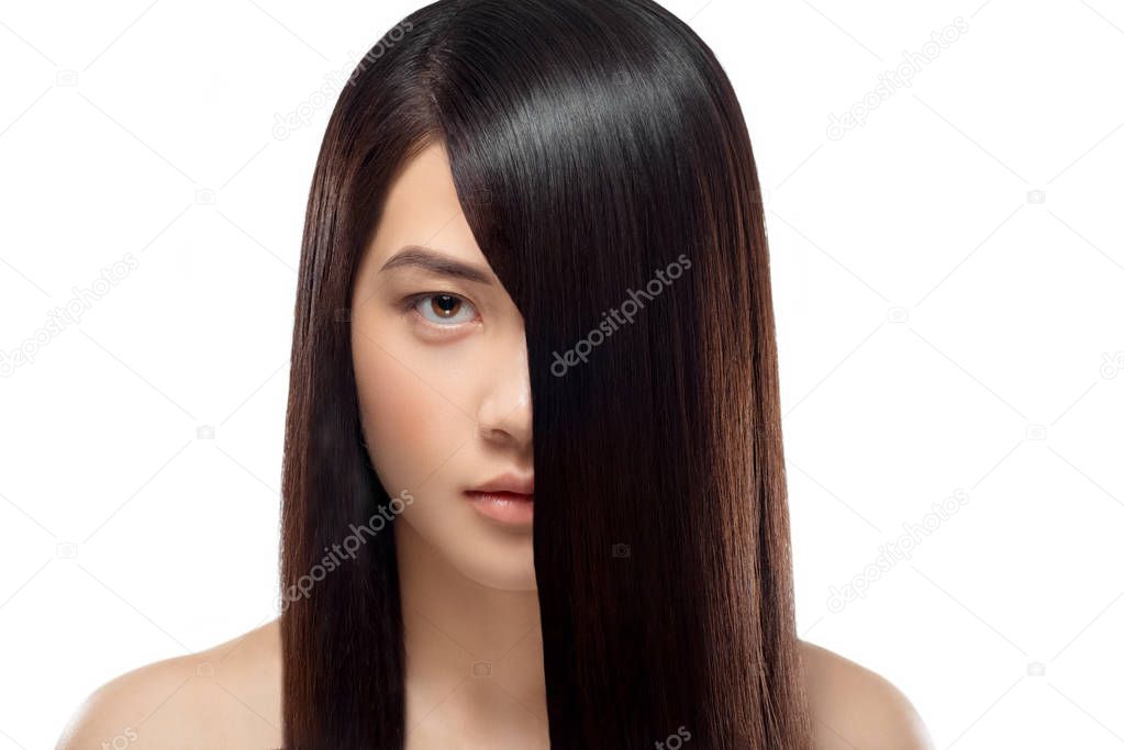 portrait of asian model with healthy and shiny hair looking at camera isolated on white