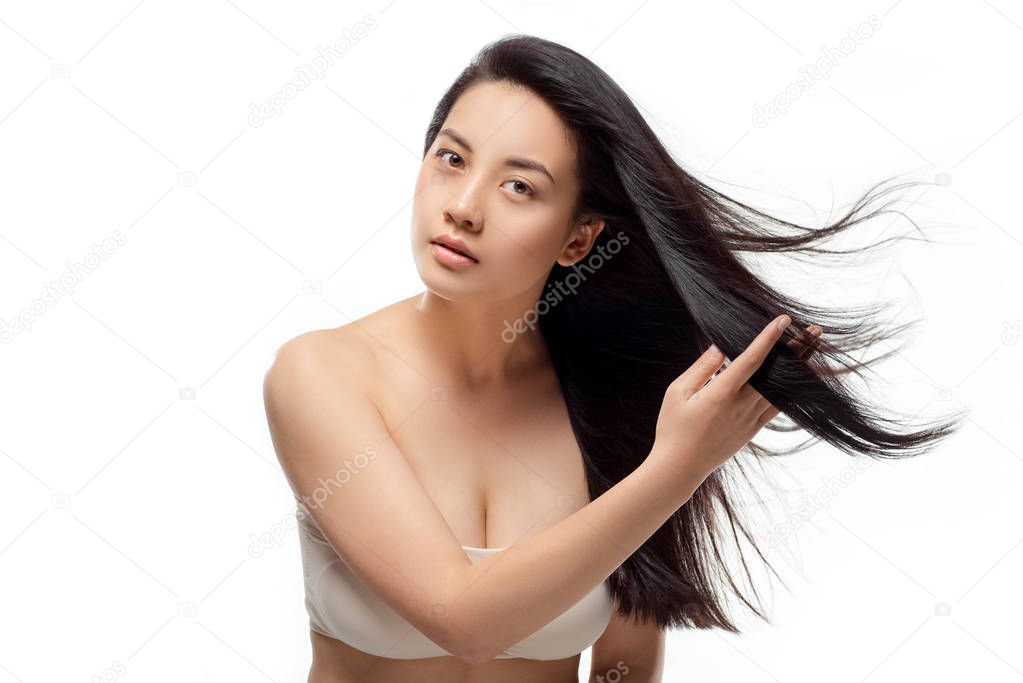 portrait of young asian woman with beautiful and healthy hair looking at camera isolated on white