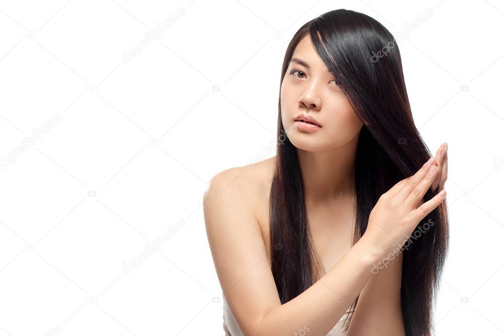 portrait of beautiful young asian woman with healthy dark hair isolated on white