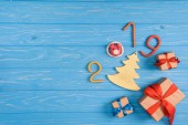 Ansicht von Geschenkboxen und 2019-Symbol auf blauer Holzoberfläche