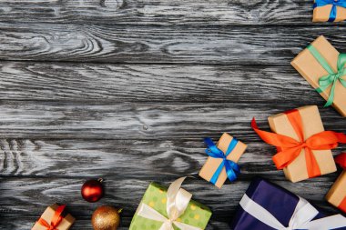 ahşap yüzey üzerinde Noel hediyeleri ve parlak baubles üstten görünüm