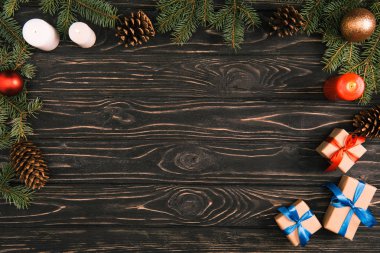 üstten görünüm Noel hediyeleri, mumlar ve köknar baubles ve çam kozalakları ahşap yüzeyde çırpı