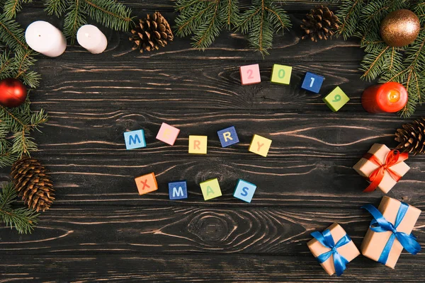 Draufsicht Auf Weihnachtliche Schriftzüge Auf Würfeln Und Geschenkboxen Mit Tannenzweigen — Stockfoto